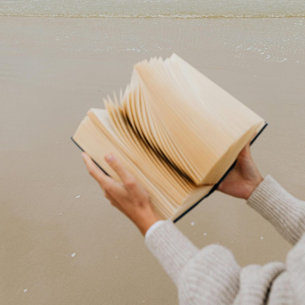 Serene beach scene with open book, perfect for relaxation and leisure themes.