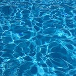 Vibrant blue swimming pool water with dynamic reflections, ideal for abstract backgrounds.